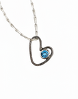 Heart-shaped pendant with a purple gemstone on a white background