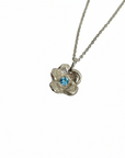 Silver necklace with a floral pendant featuring a red gemstone on a white background
