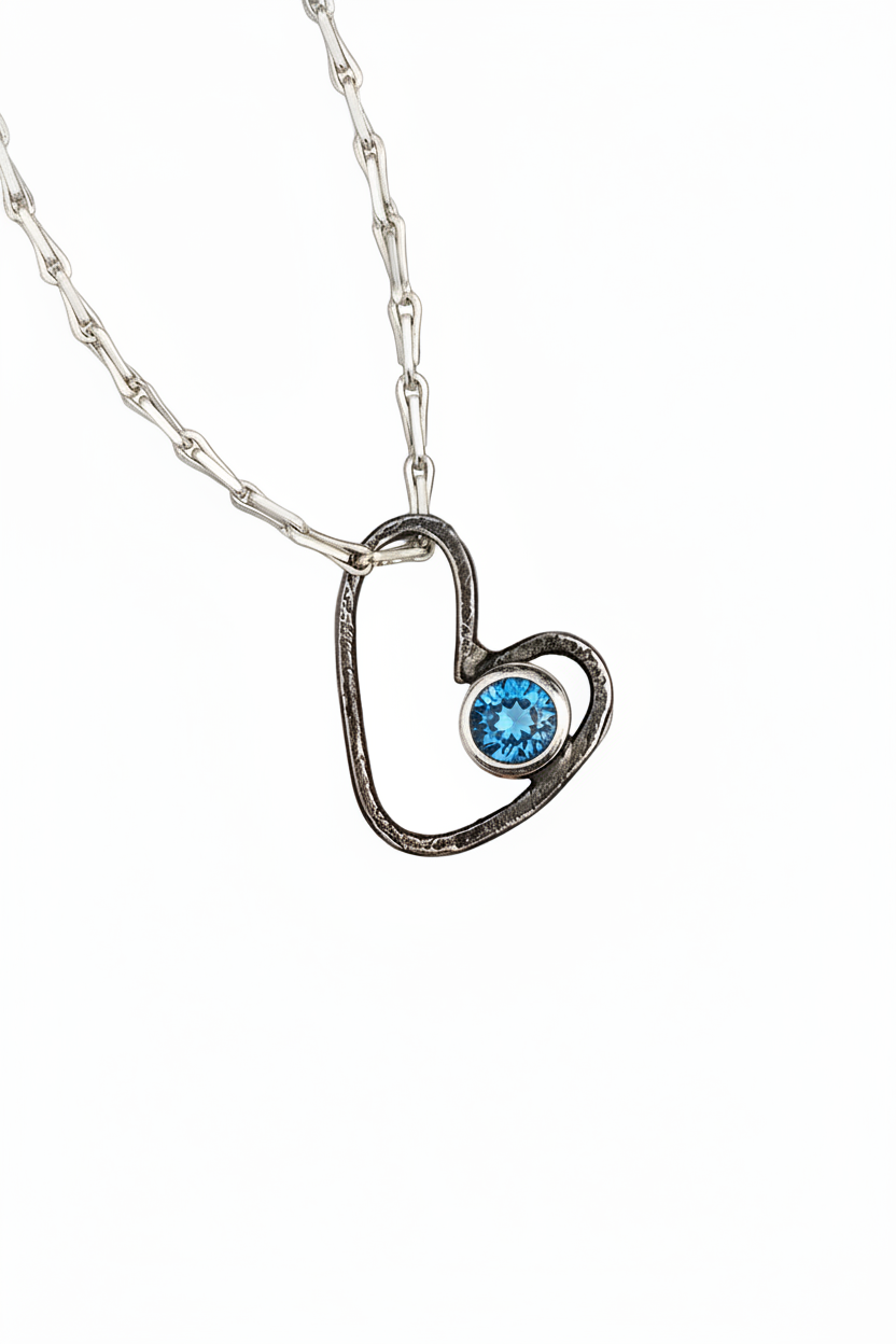 Heart-shaped pendant with a purple gemstone on a white background