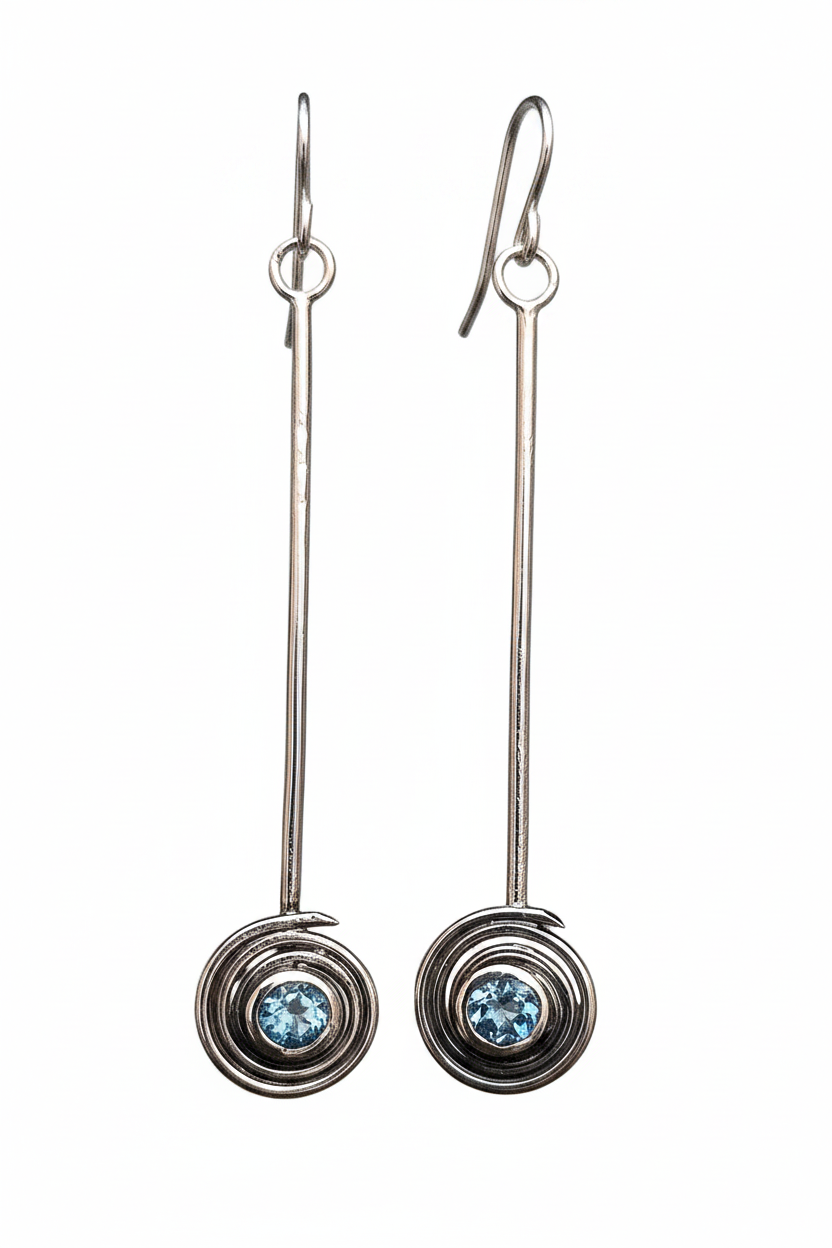 Pair of silver earrings with blue topaz gemstones on a white background
