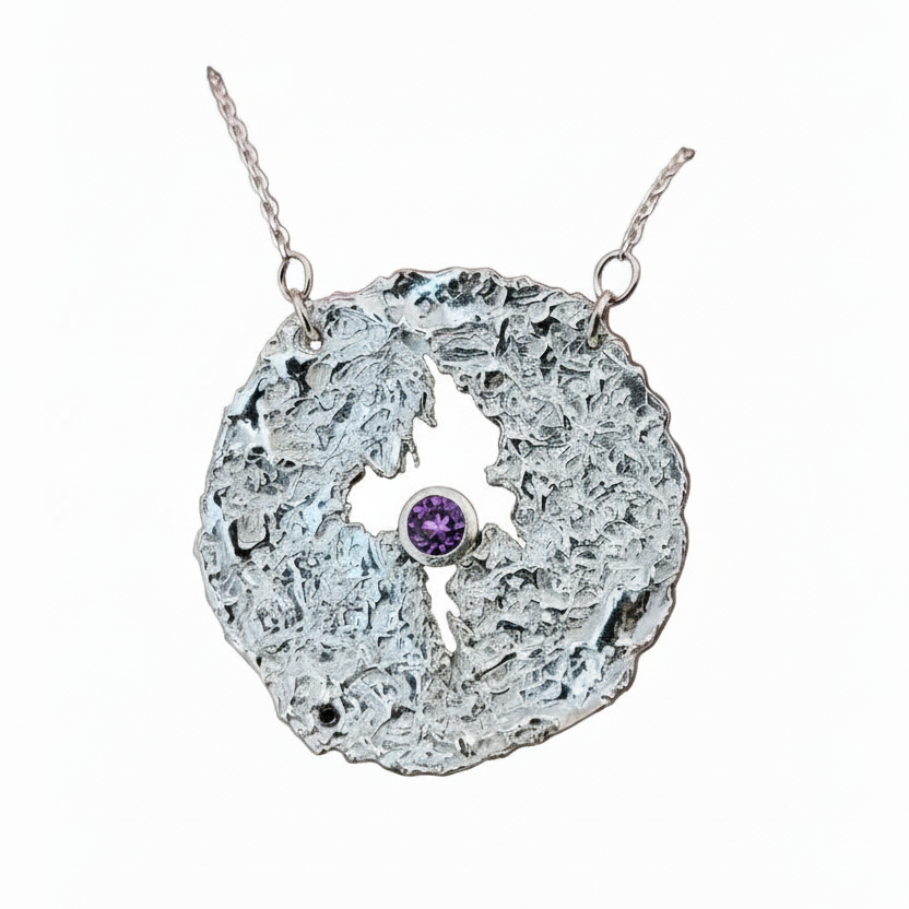 Silver necklace with a textured pendant featuring a blue gemstone on a white background